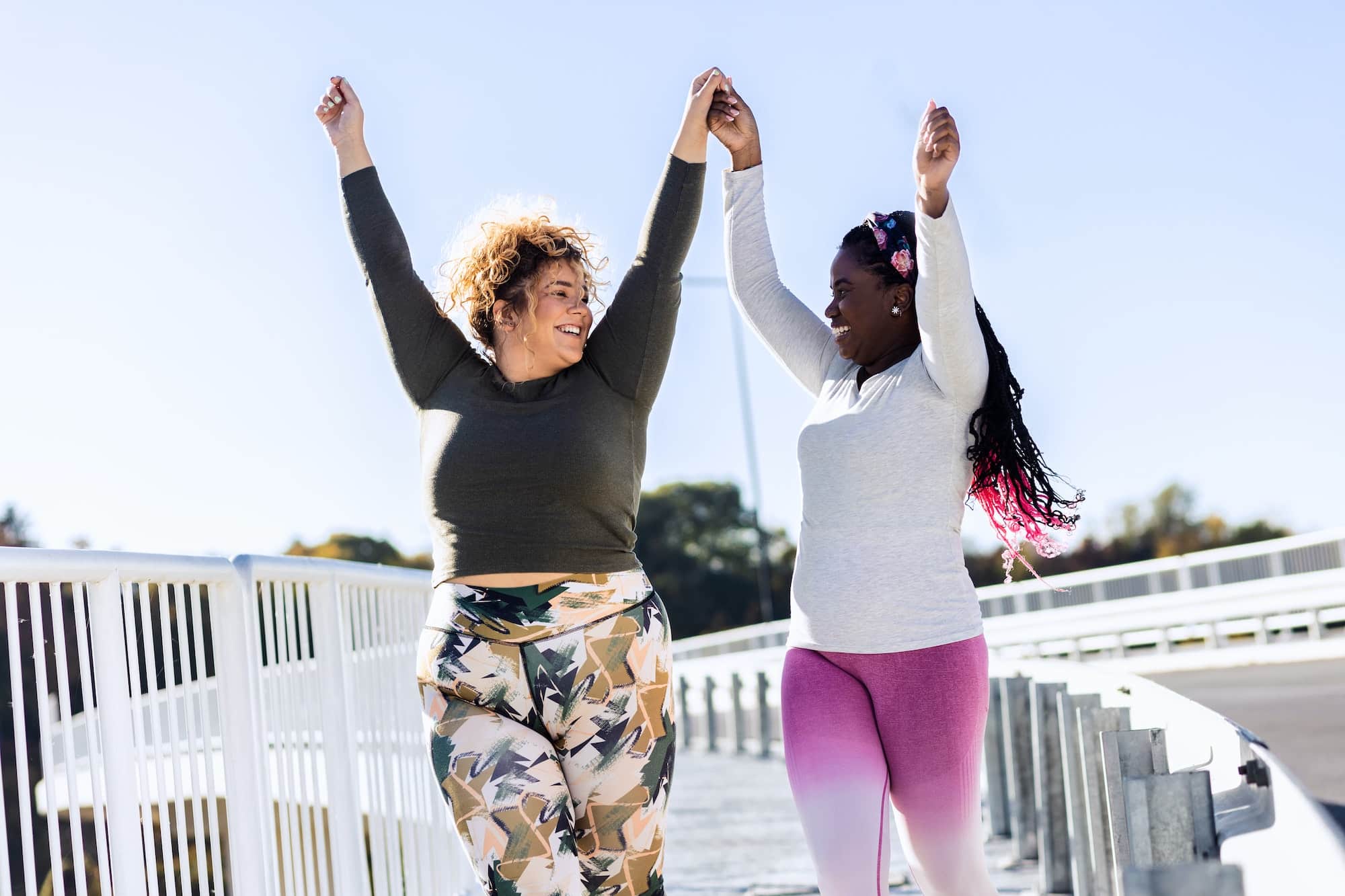 Two young plus size women jogging together.
